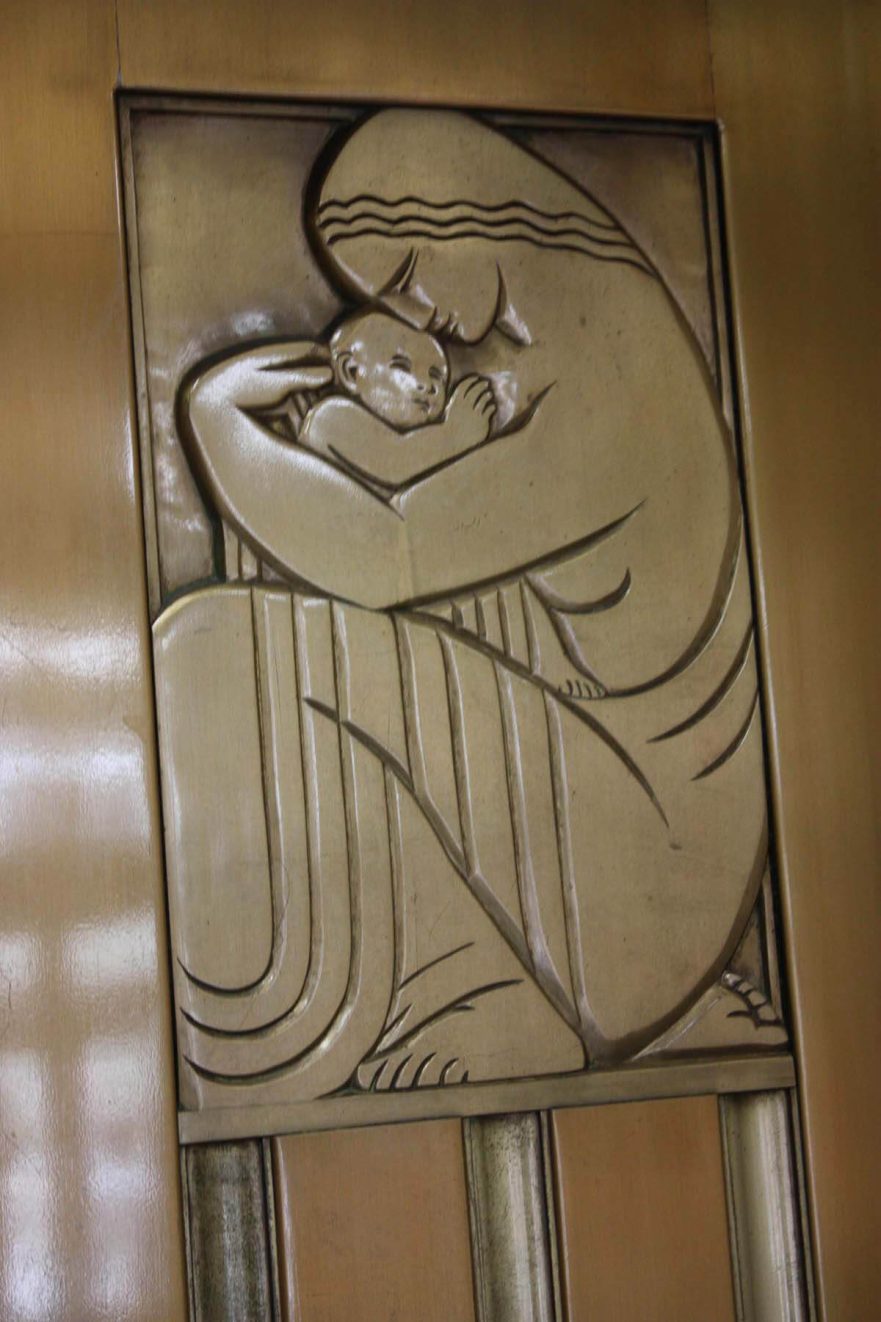 Close up of the figure on the right elevator door in the main lobby.