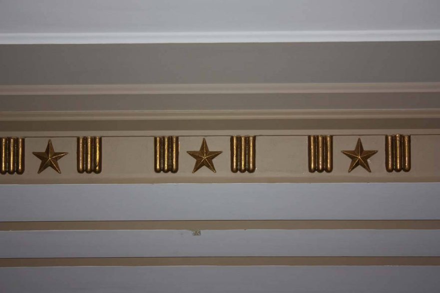 Plaster ceiling molding in main floor lobby has a design of 3 rods, a star and 3 rods.