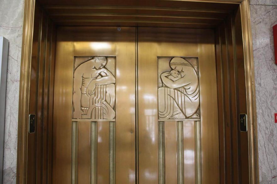 Elevator doors on main floor lobby. They are bronze and were designed by Alfonos Iannelli, an Italian-American sculptor and industrial designer. Iannelli gained a significant reputation when he was invited to work with Frank Lloyd Wright, on the Hyde Park “Midway Gardens” project in 1914, creating several of the “sprite sculptures.”