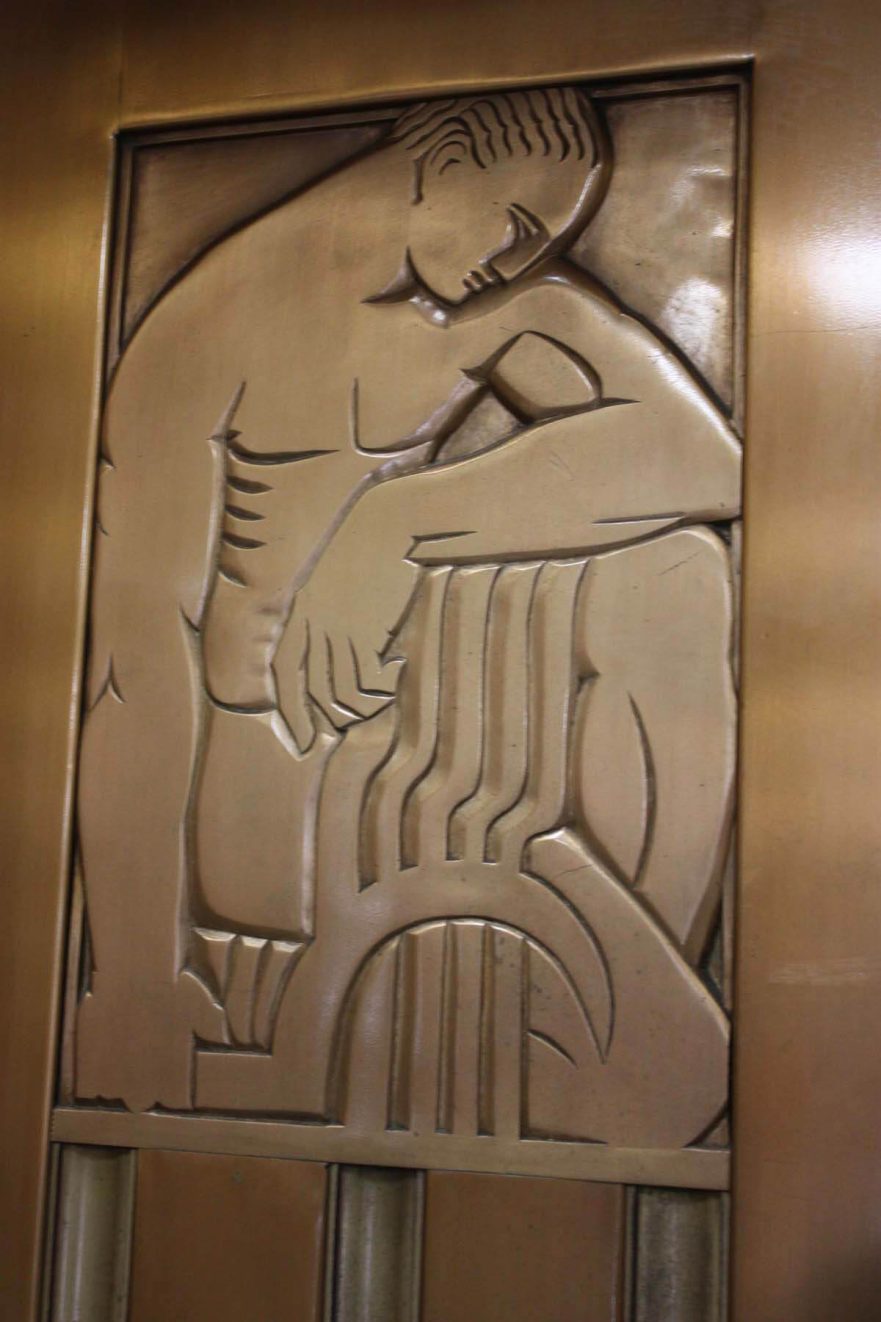 Close up of the figure on the left elevator door in the main lobby.