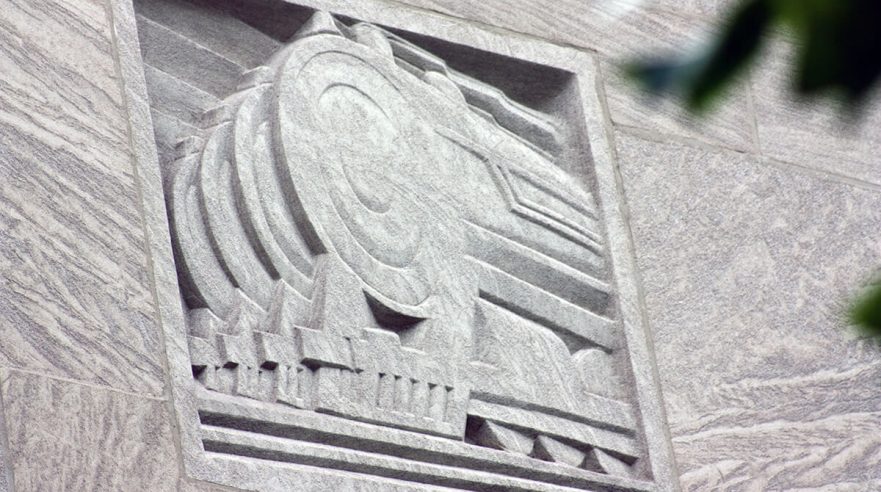 Carving on the upper area of the north and south extensions of City Hall, this is an Art Deco representation of trains, circa 2022.
